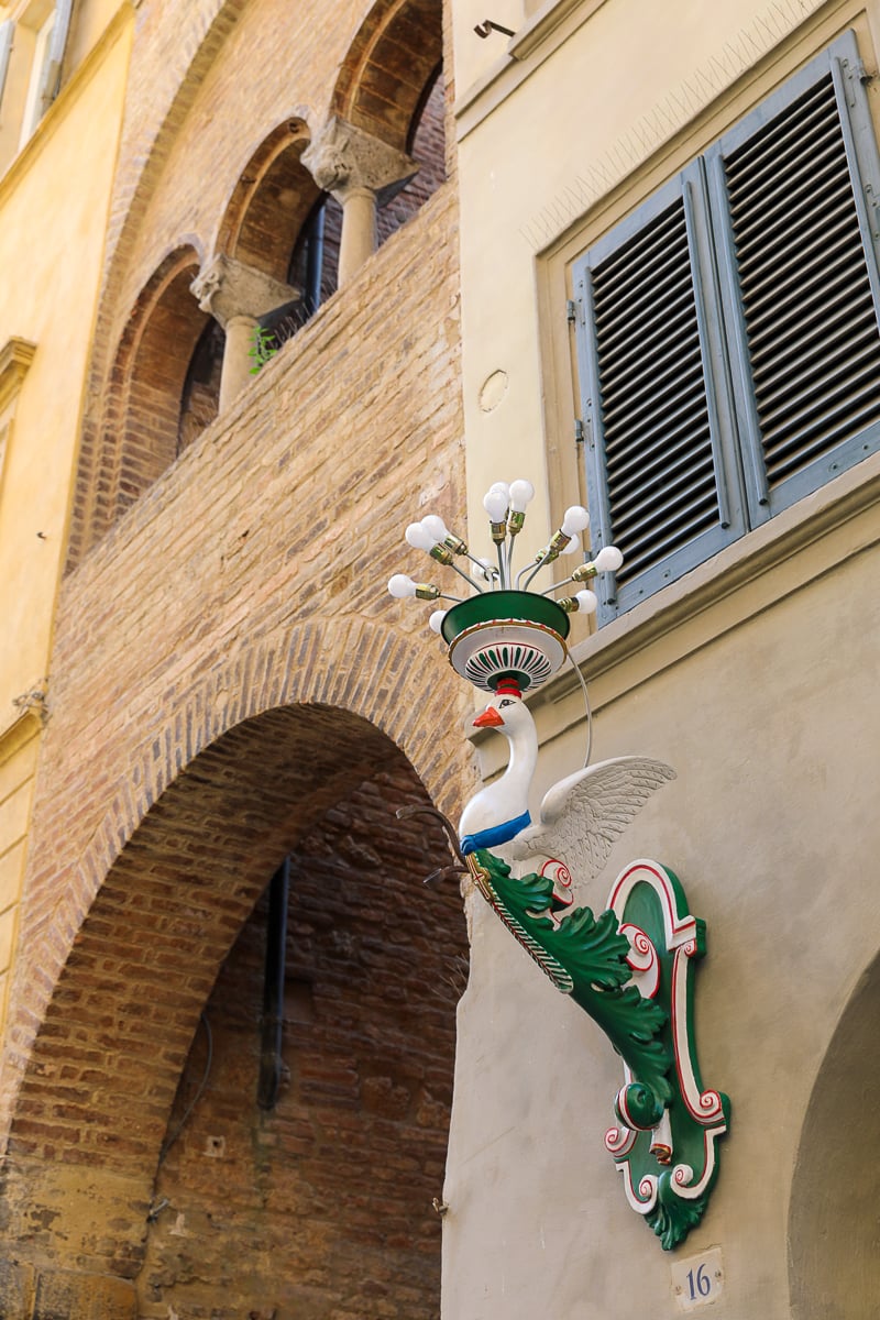 Traditional contrada lantern hanging on a Siena street, representing the city’s historic neighborhoods