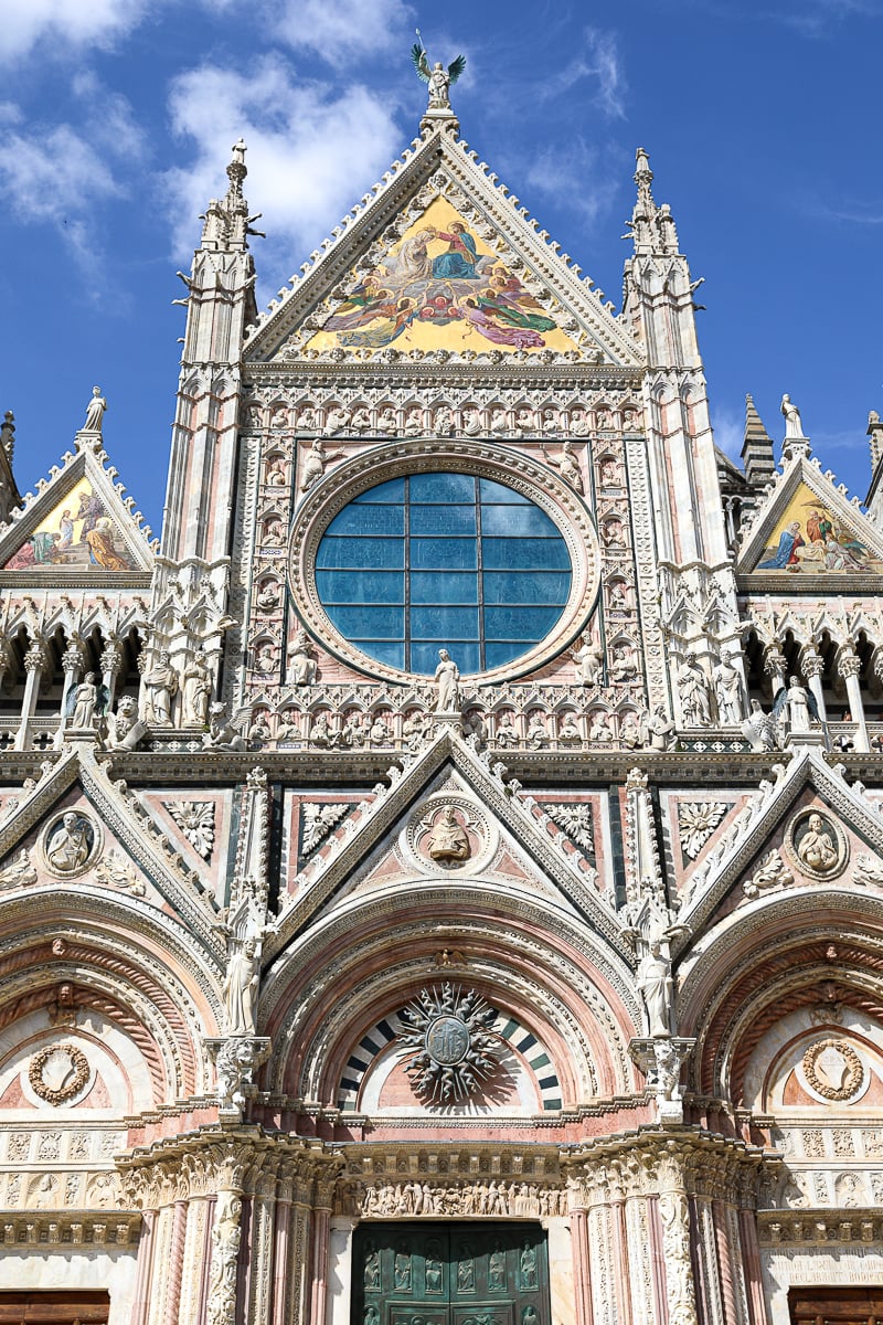 Ornate black-and-white marble facade of the Duomo di Siena, one of the most impressive cathedrals in Tuscany, Italy