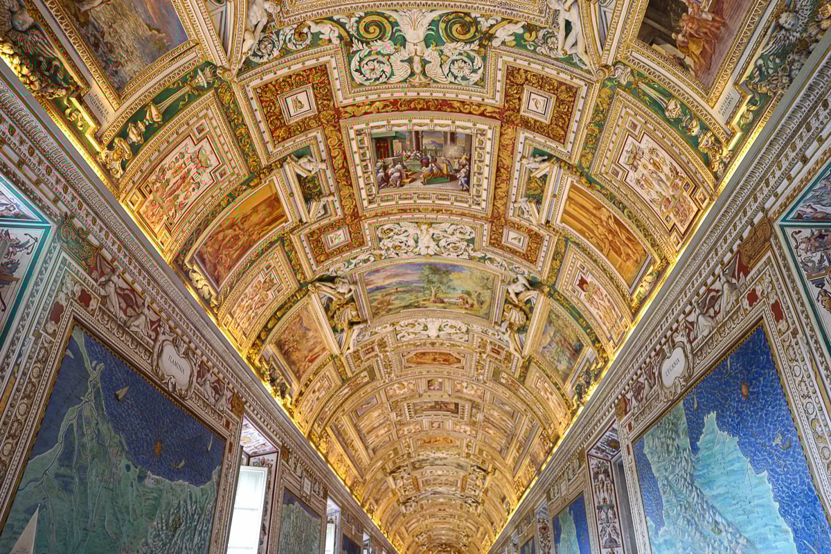 Ornate ceiling of the Gallery of Maps in the Vatican Museums with detailed frescoes and gold decorative elements