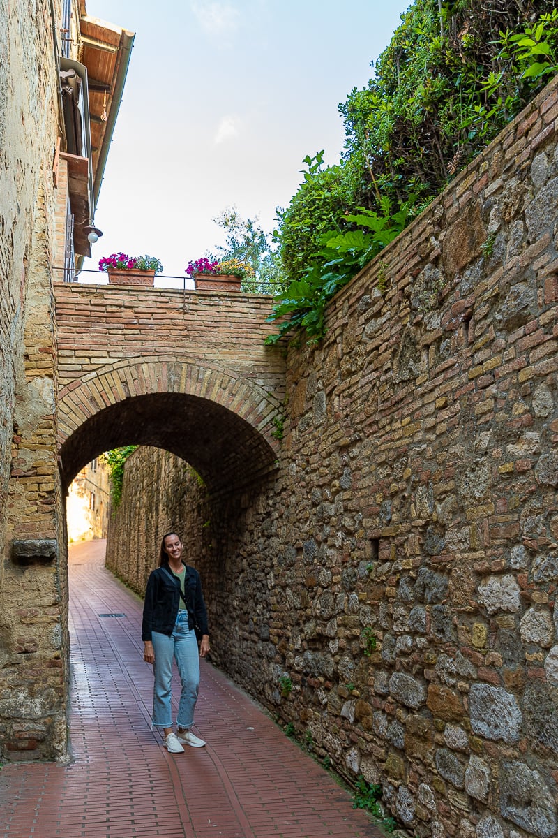 Narrow stone alleyway with archway in the historic center of San Gimignano