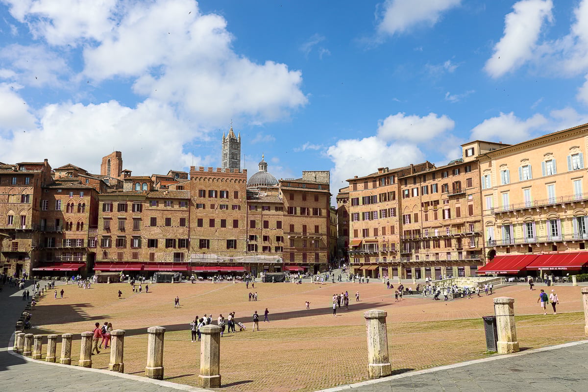 Curved medieval buildings lining Piazza del Campo in Siena on a sunny day