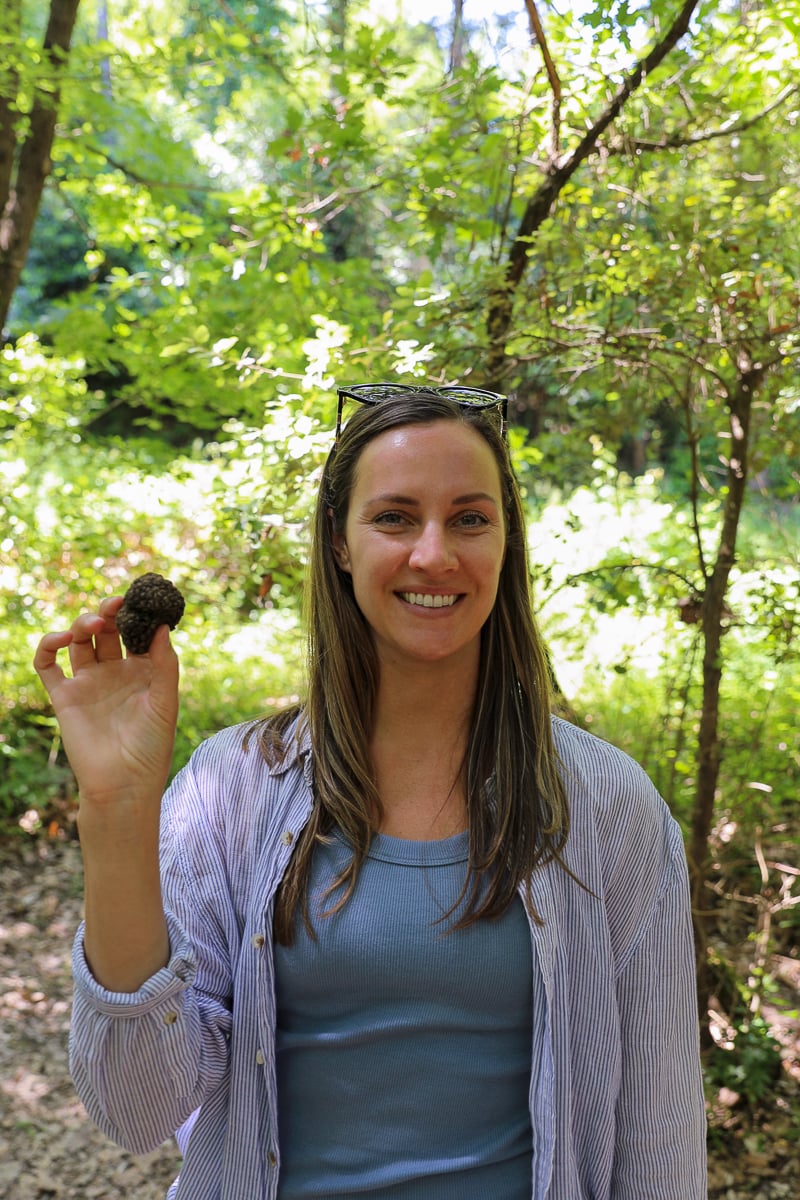 Maddy holding a freshly found truffle during a truffle hunt in Tuscany