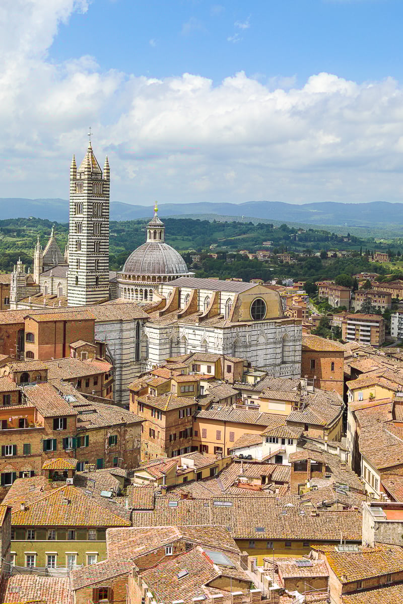 Panoramic view of Siena rooftops with the Duomo di Siena and Tuscan countryside in the background