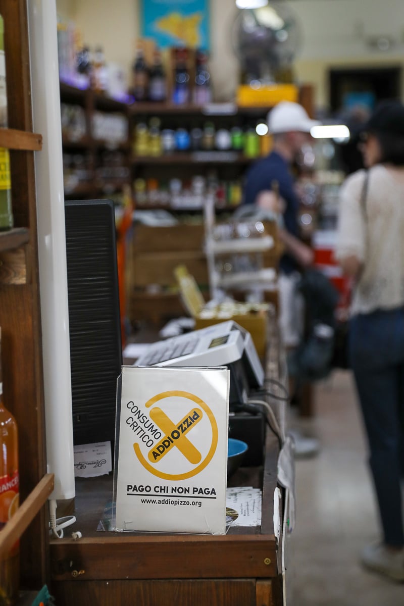 Addiopizzo “consumo critico” sign promoting anti-mafia ethical shopping inside a Palermo shop in Sicily