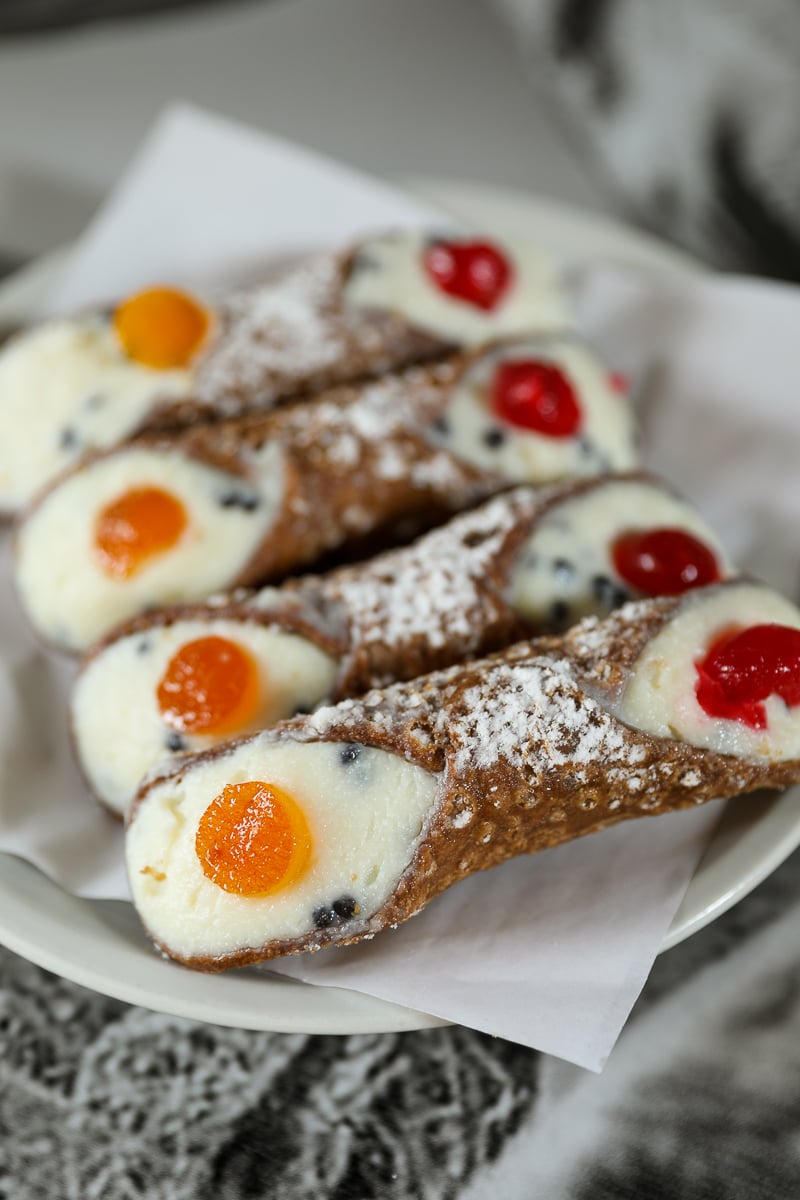 Classic Sicilian cannoli filled with ricotta and topped with candied fruit, dusted with powdered sugar in Palermo