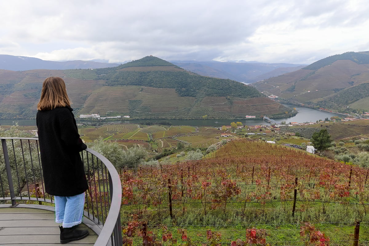 Woman overlooking the Douro River and terraced vineyards from a scenic viewpoint in Portugal’s Douro Valley