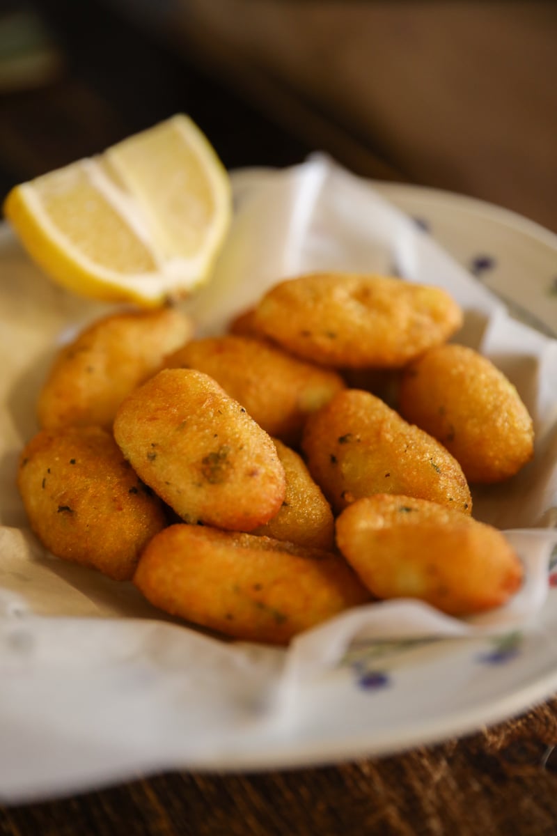 Golden potato crocchè (crocchè) with lemon wedge, classic Palermo street food in Sicily