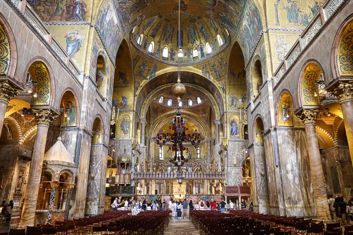 St. Mark’s Basilica interior – central nave with marble columns, chandeliers, and shimmering mosaics