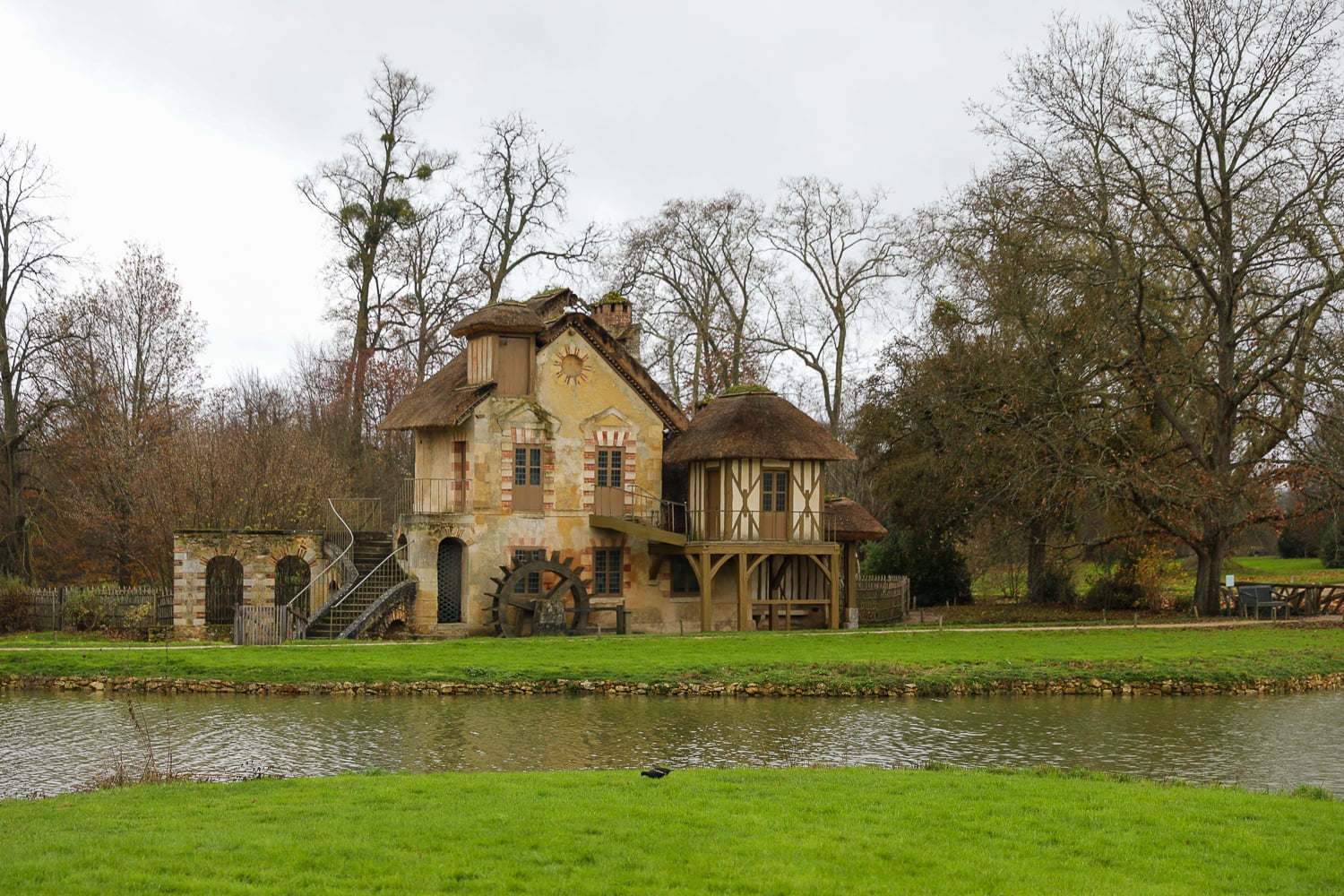 Queen’s Mill at Marie Antoinette’s Hamlet with a waterwheel beside the lake at Versailles