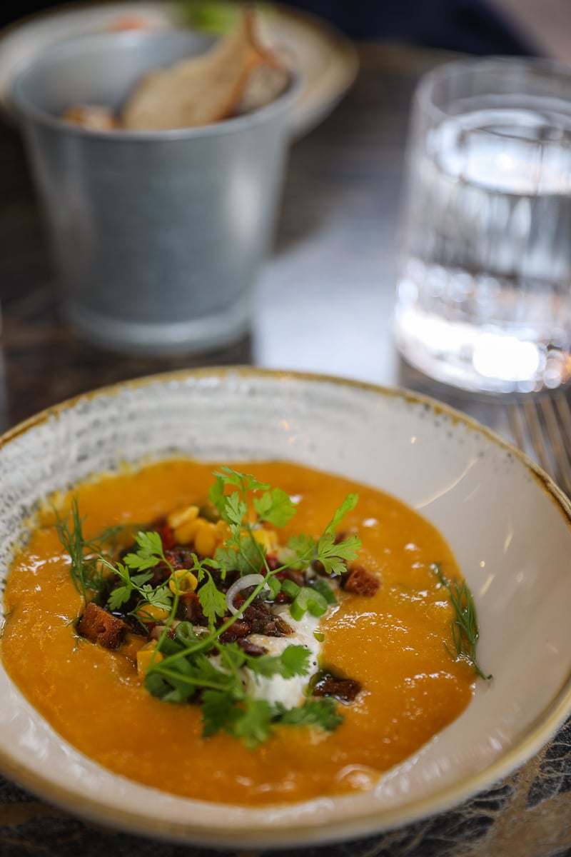 Soup garnished with fresh herbs and croutons at Bonbonne, Bayeux, France
