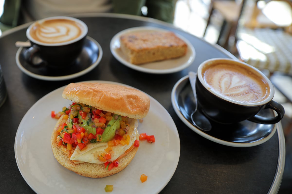 Halloumi brioche burger with avocado and pico de gallo alongside flat whites at Bisette café