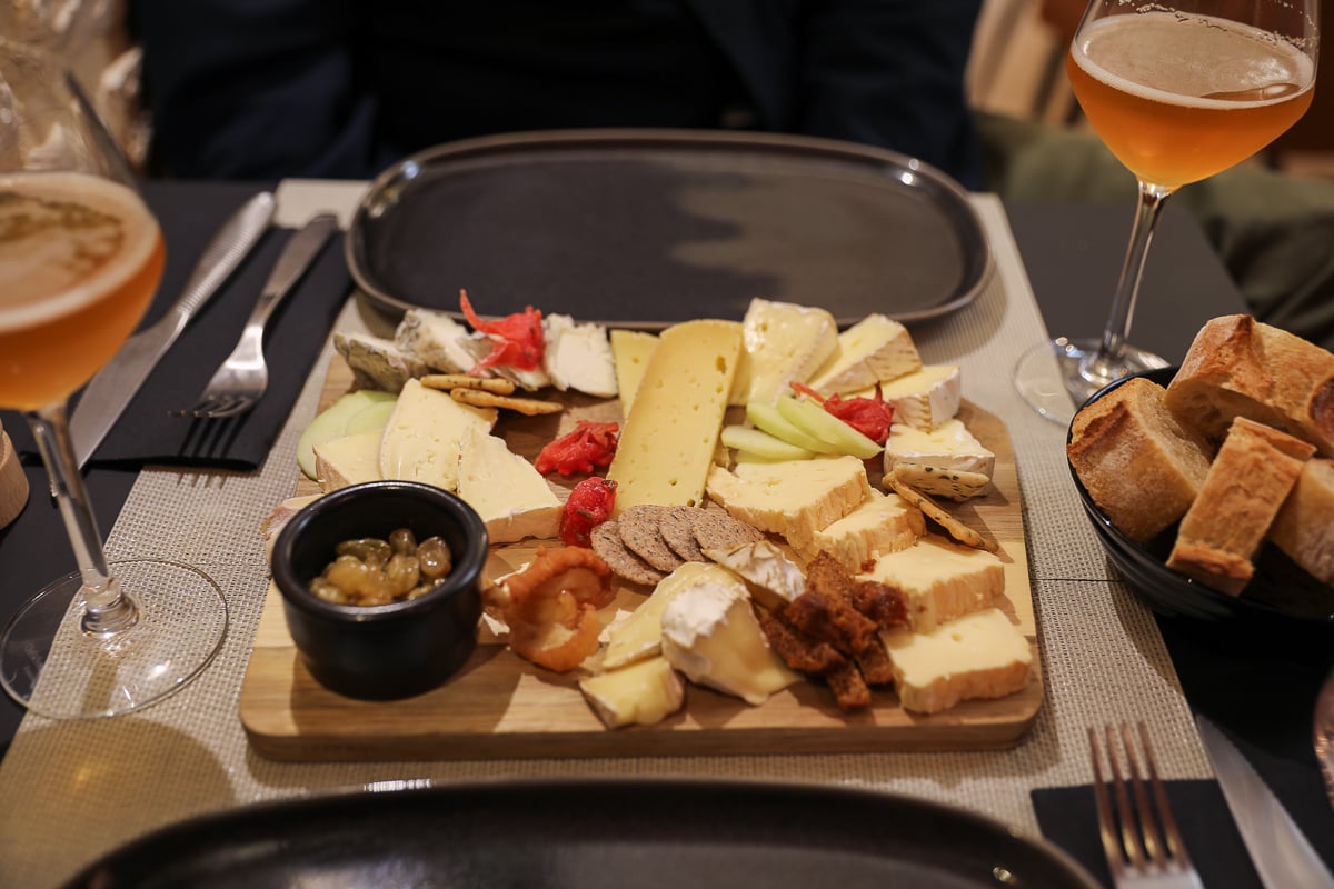 Norman cheese board with Camembert, Pont-l'Évêque, crackers, and local cider at La Fromagerie de Bayeux, Normandy