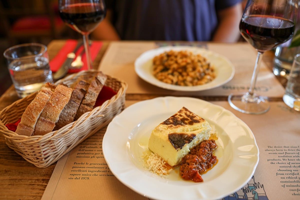 Ricotta flan with ragù, white beans, and crusty bread on the table at Cibrèo Trattoria in Florence.