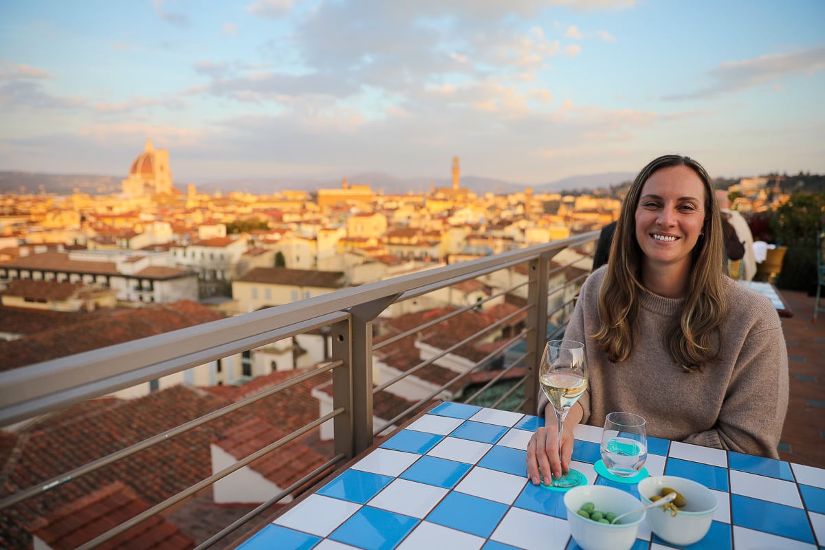 Maddy enjoying a glass of white wine at sunset with views of the Florence Duomo from Cosimo Rooftop Bar.