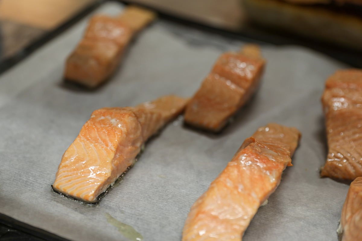 Pieces of baked salmon resting on parchment paper.