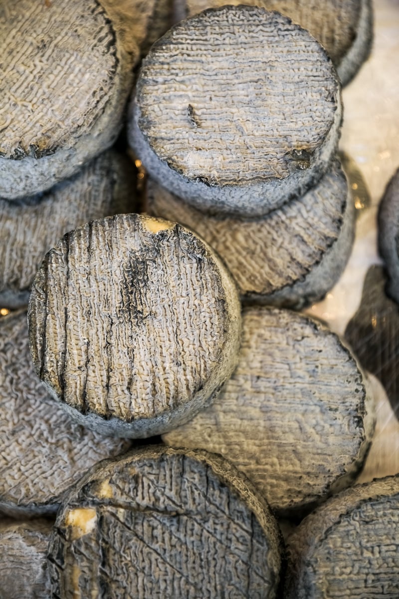 Stacked rounds of ash-rinded goat cheese at a Latin Quarter market in Paris.