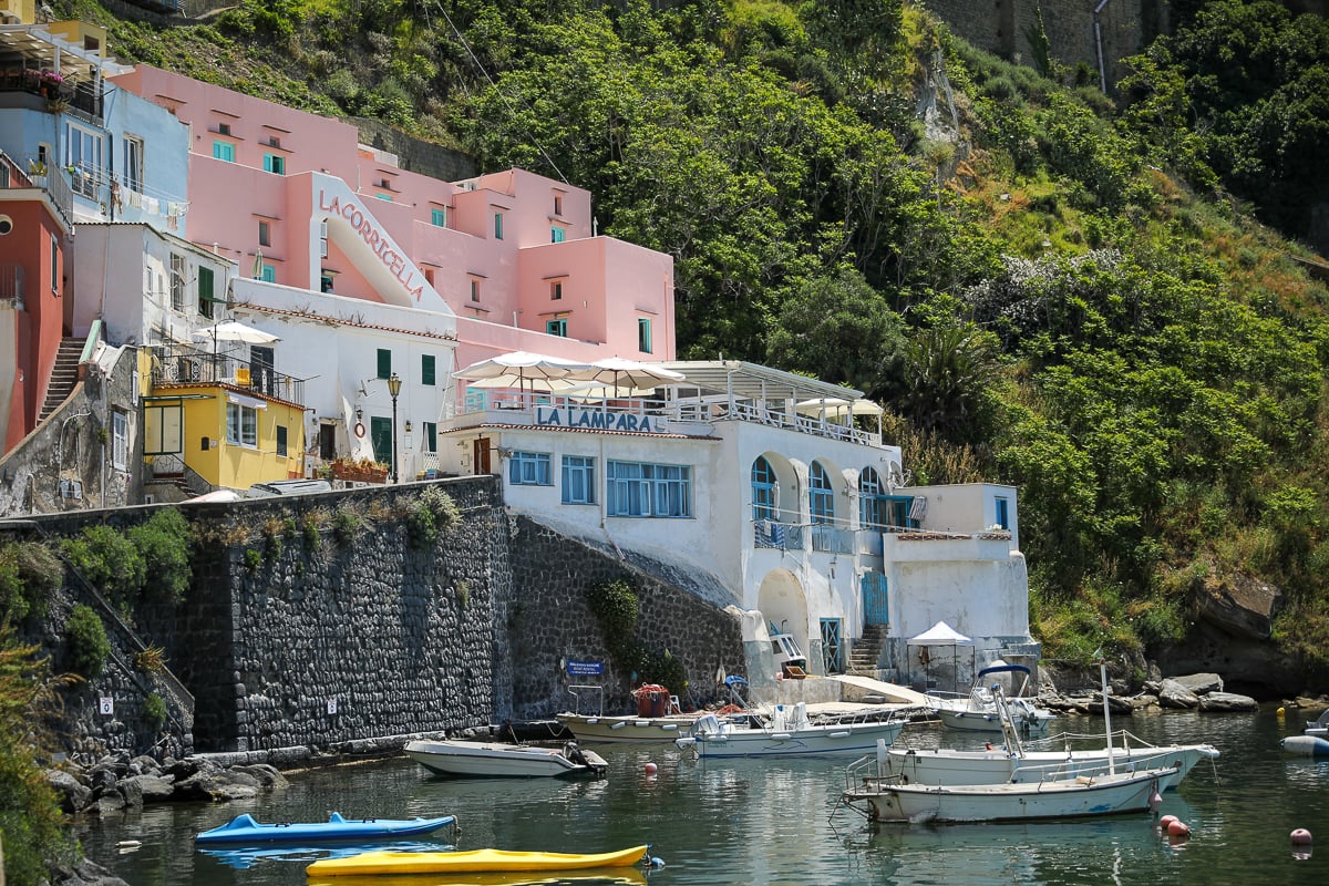Pink Hotel La Corricella and La Lampara restaurant above small boats at the harbor's edge