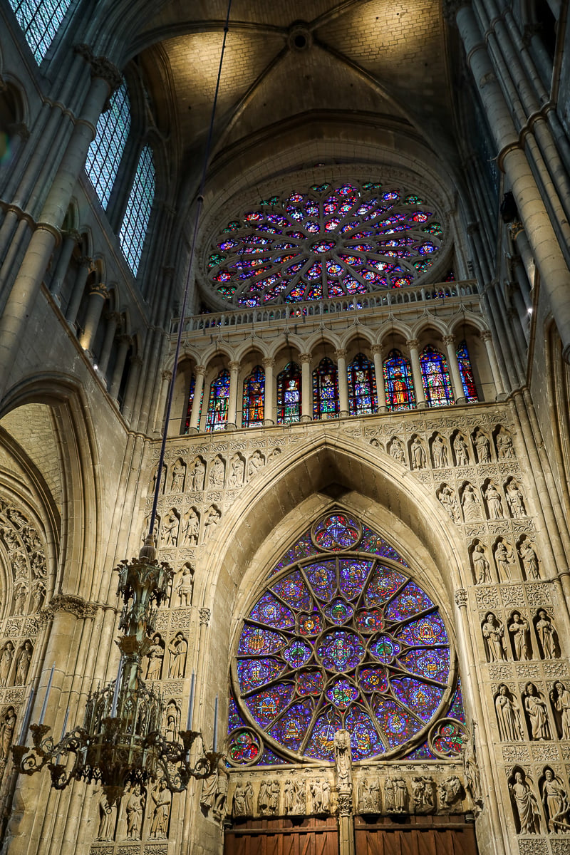 Stained glass rose windows and carved stone inside Notre-Dame de Reims Cathedral