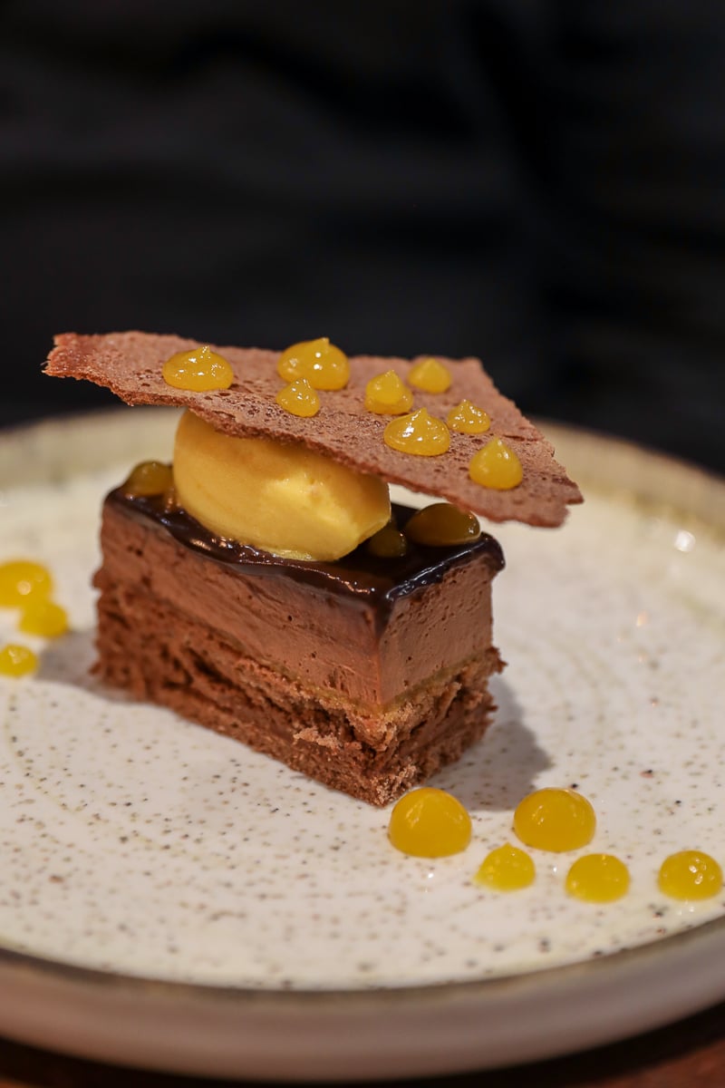 Layered chocolate mousse dessert with caramel and a crispy tuile at L'Alcôve restaurant, Bayeux