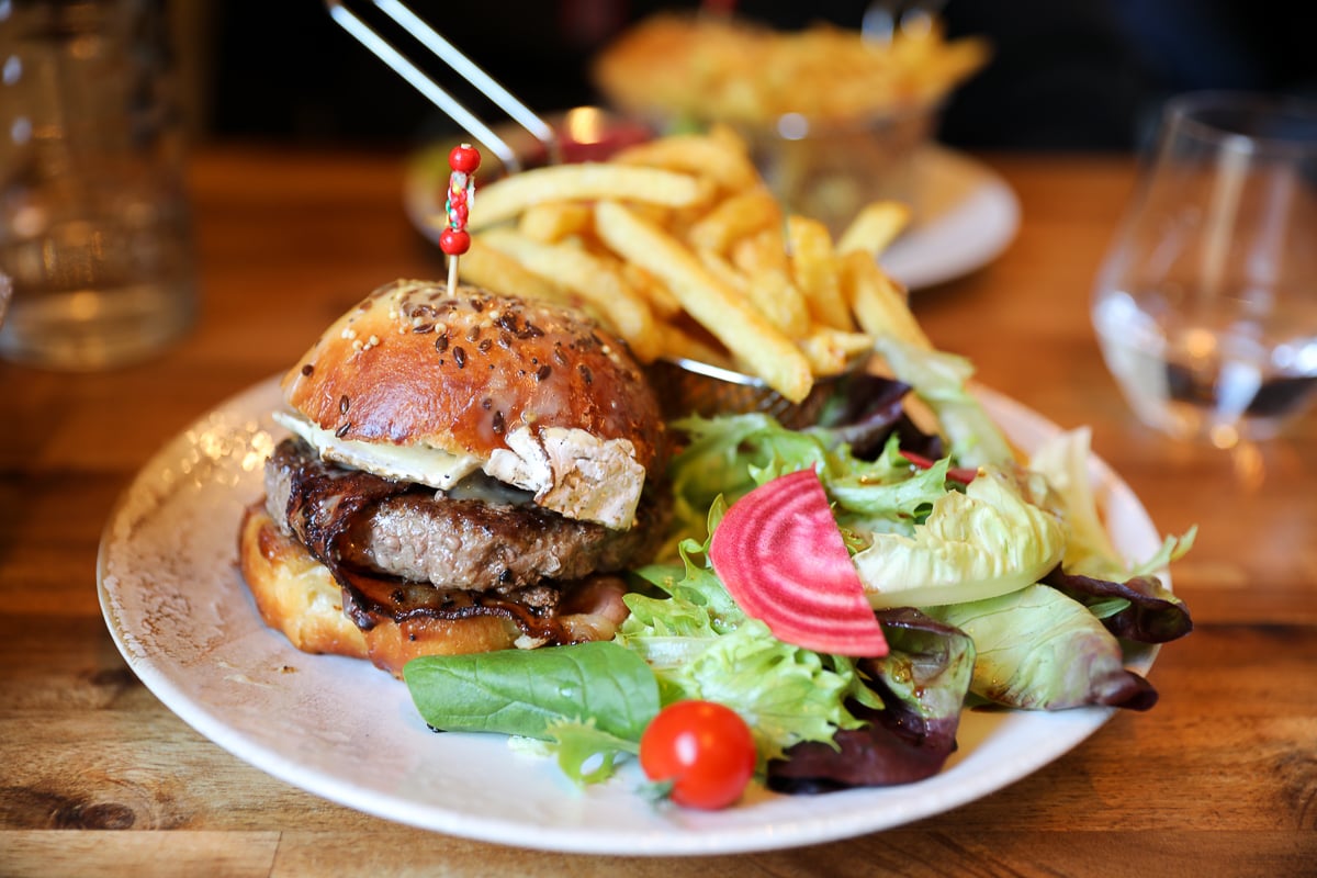 Burger with melted Camembert, caramelized onions, and fries at La Normande restaurant in Bayeux