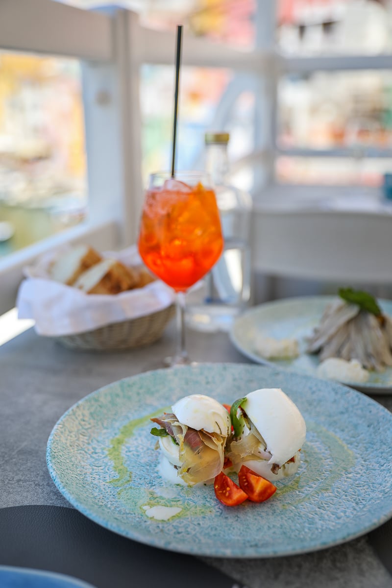 Fresh mozzarella with cherry tomatoes and an Aperol Spritz at a harbor-view table at La Lampara