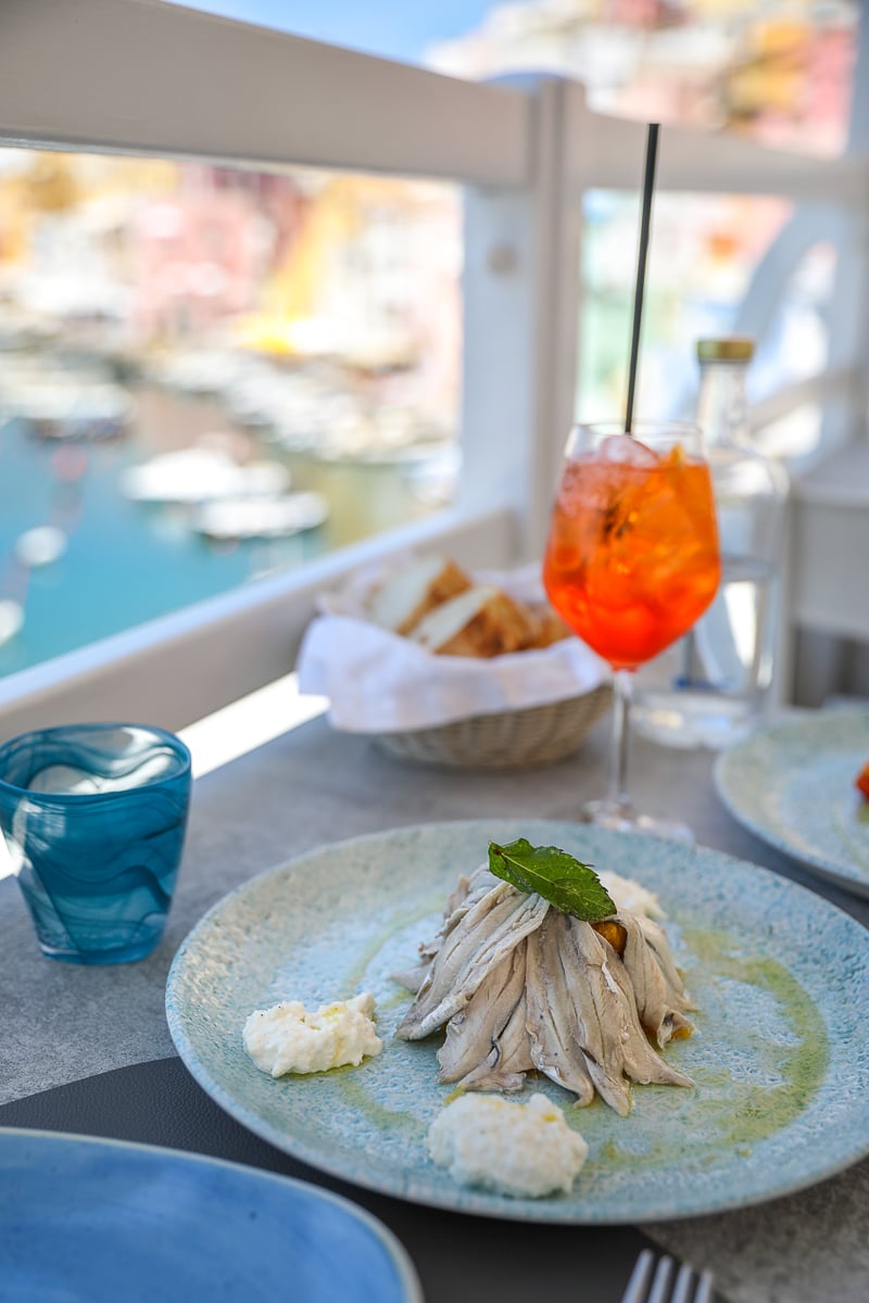 Marinated fish with burrata and an Aperol Spritz at a table above the marina, La Lampara in Procida, Italy