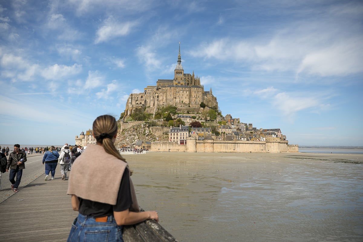 Maddy looking out at Mont Saint-Michel rising from the tidal flats on a day trip from Bayeux, Normandy
