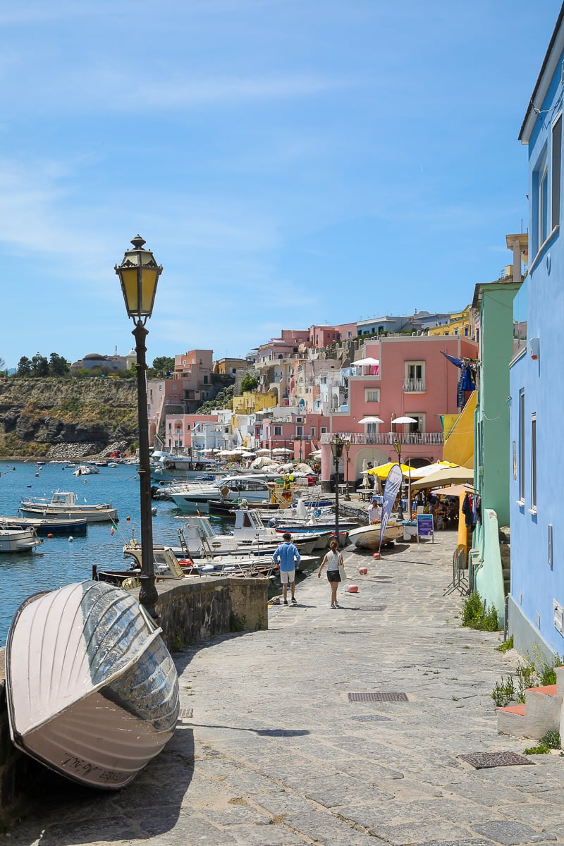 Street lamp and overturned boat on the quay along Marina Corricella's pastel waterfront in Procida