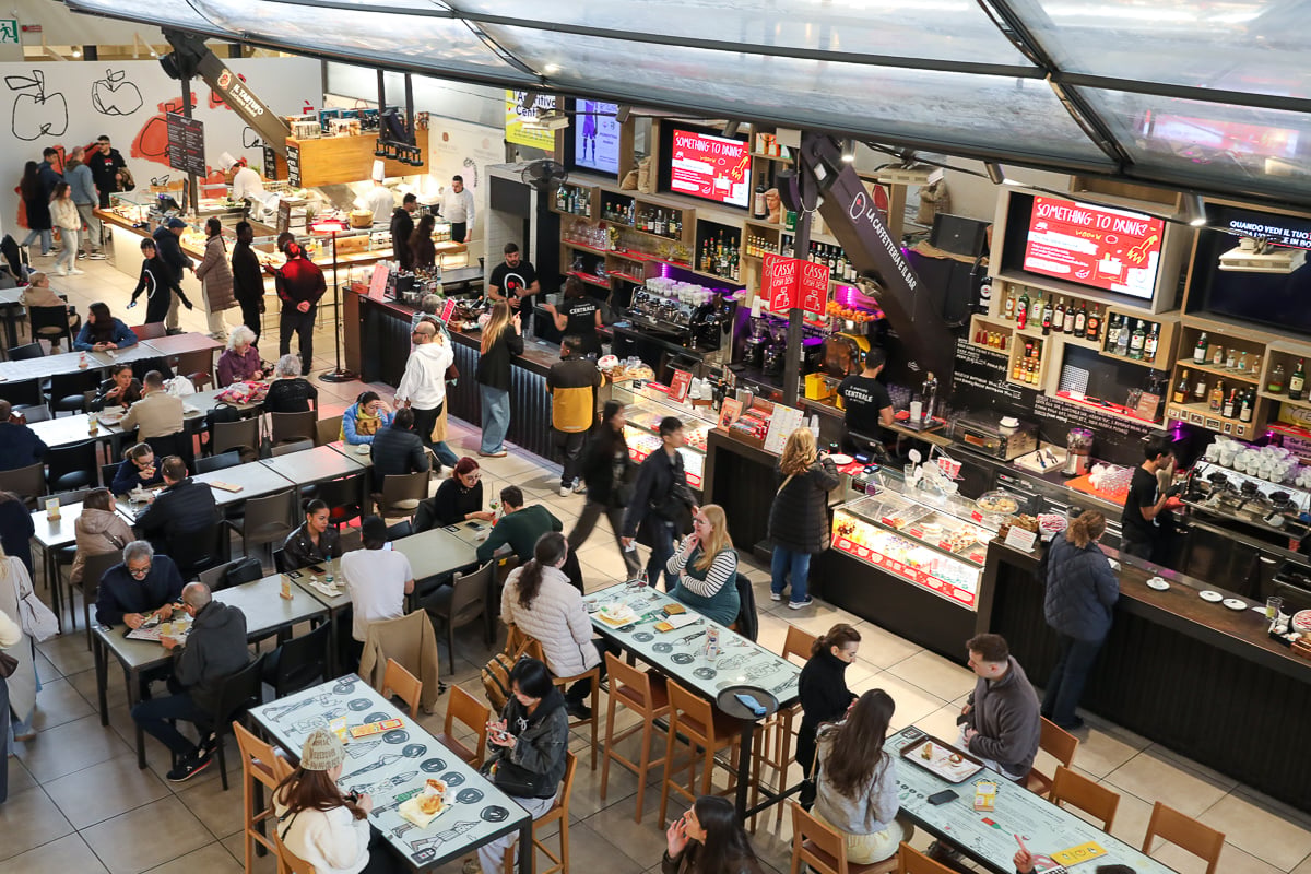 Aerial view of the bustling upstairs food hall at Mercato Centrale in Florence, packed with diners and food stalls.