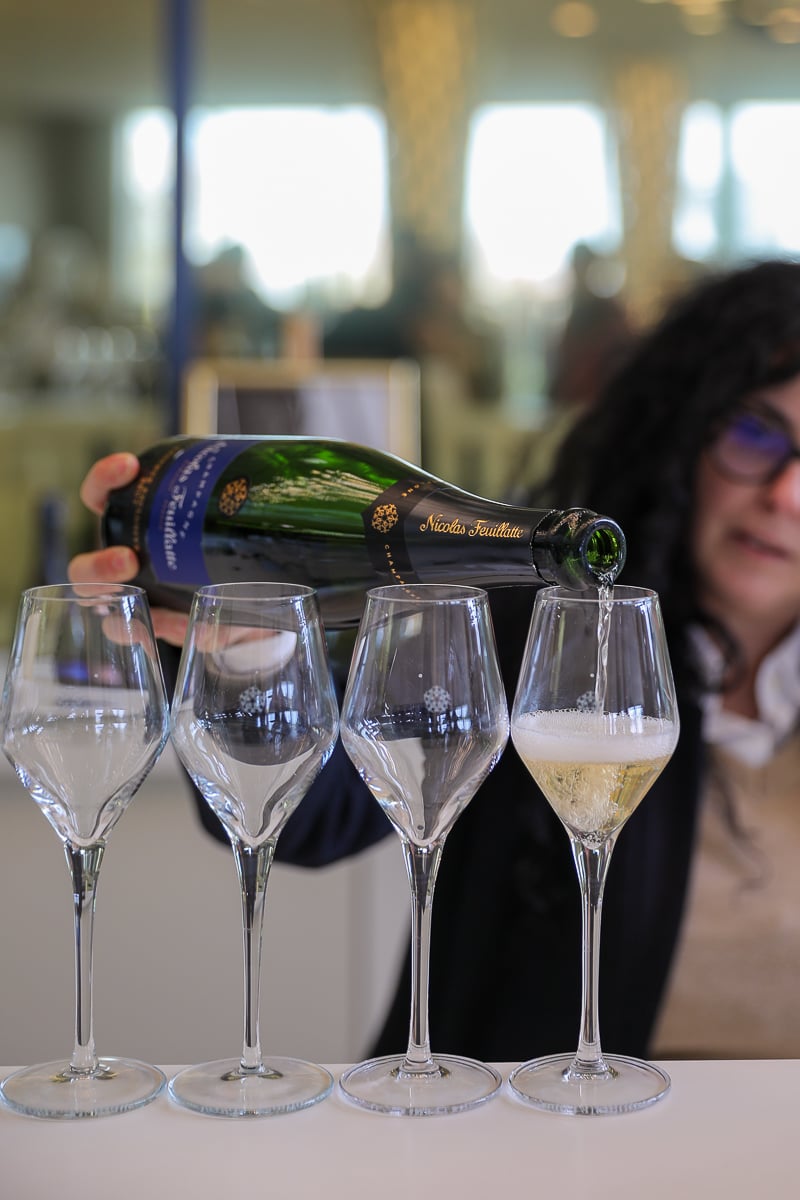Server pouring Nicolas Feuillatte Champagne into a row of tasting glasses