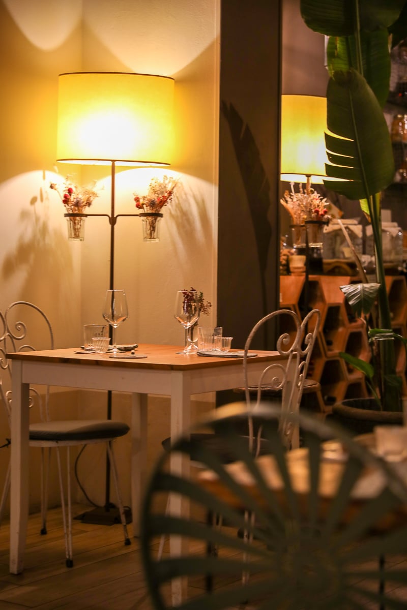 Table setting in the warm, plant-filled dining room at Nugolo restaurant in Florence.
