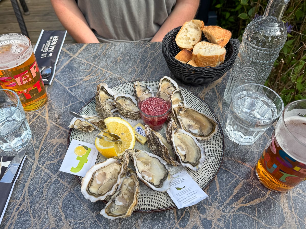 A dozen freshly shucked Norman oysters with shallot vinegar, lemon, and local craft beers at Le Garde Manger, Bayeux
