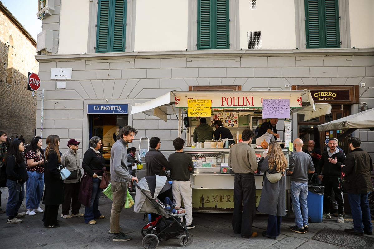 Line of customers waiting at the Pollini lampredotto stand, a classic tripe sandwich stall near Sant'Ambrogio.