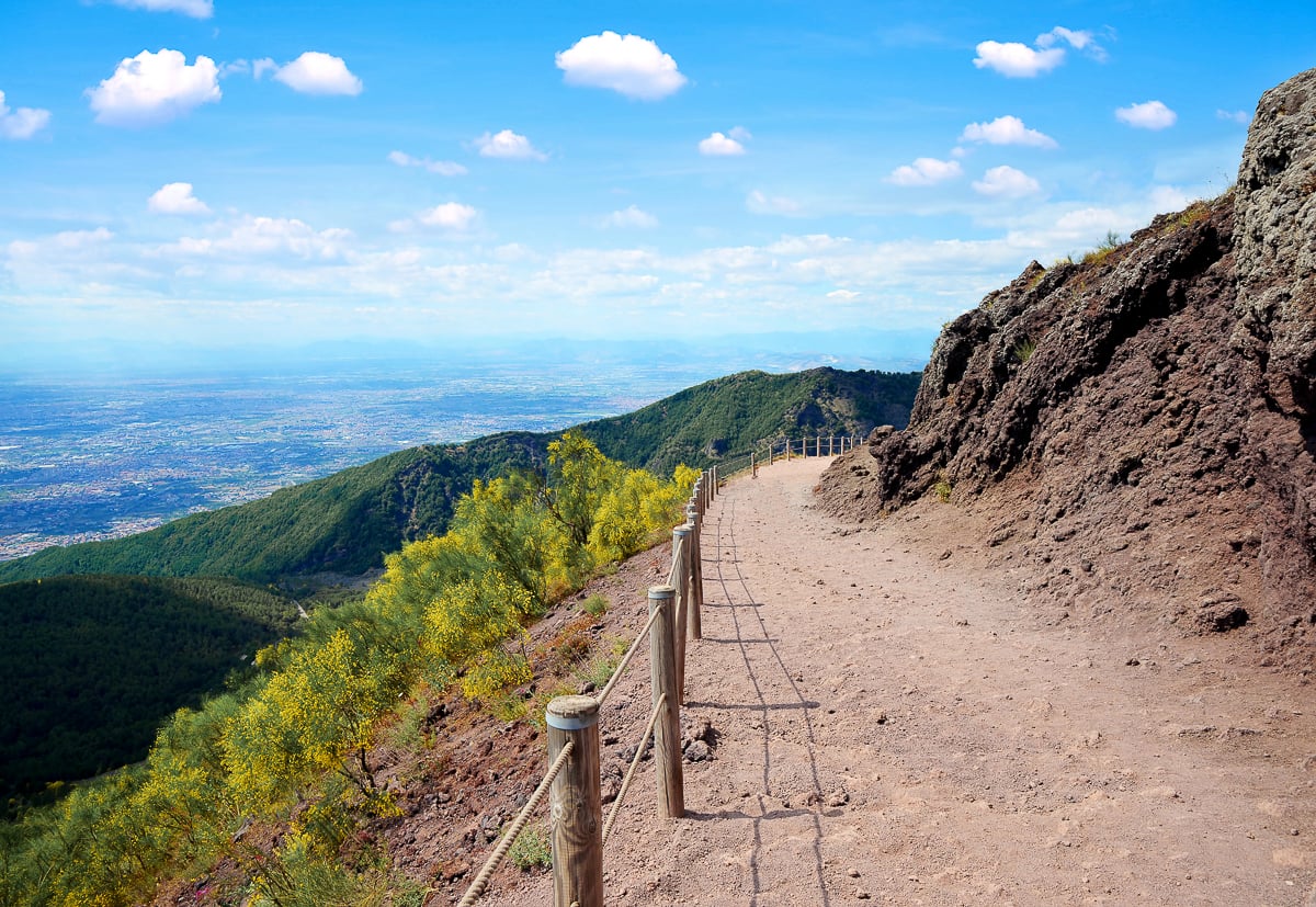 Dirt hiking path along the crater rim of Mt. Vesuvius, one of the most popular Naples day trips for sweeping Bay views