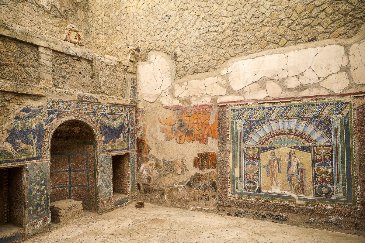 Intricately detailed mosaic wall depicting animals and mythological figures inside a well-preserved Herculaneum villa