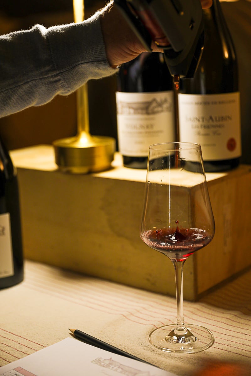 Red Burgundy wine being poured during a cellar tasting near Beaune, France