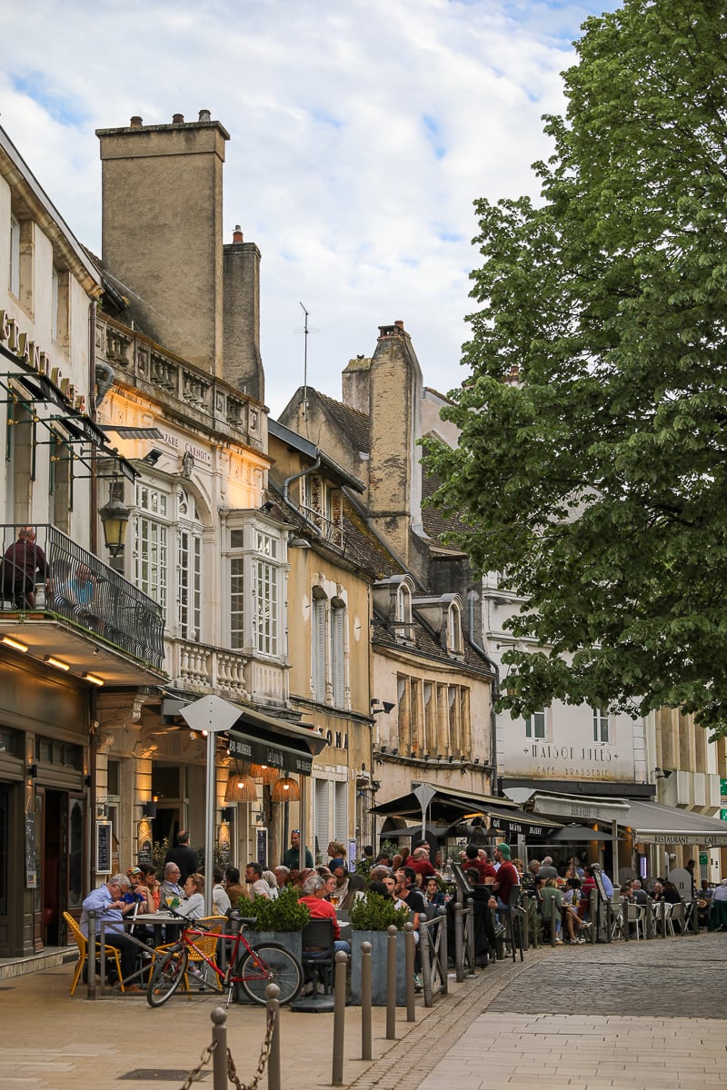 Outdoor restaurant terraces along a historic street in the old town of Beaune, Burgundy, France