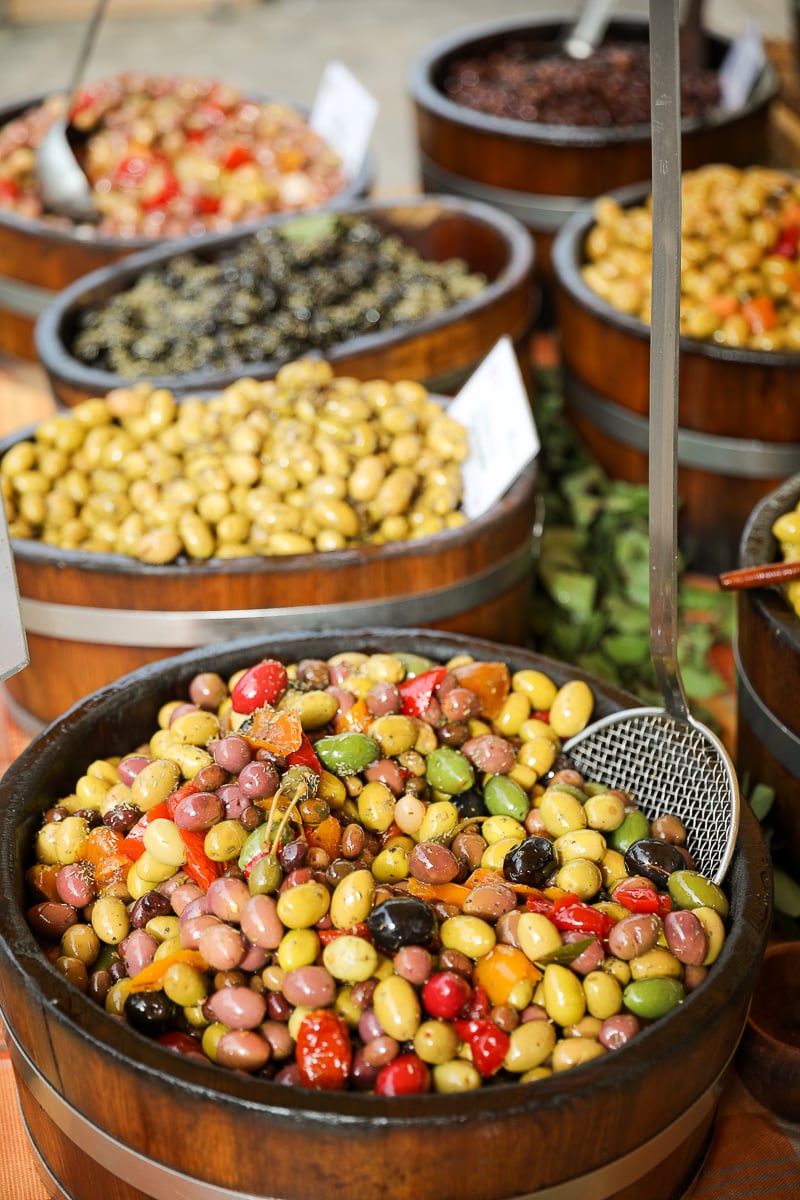 Colorful barrels of marinated olives at the Saturday market in Beaune, France