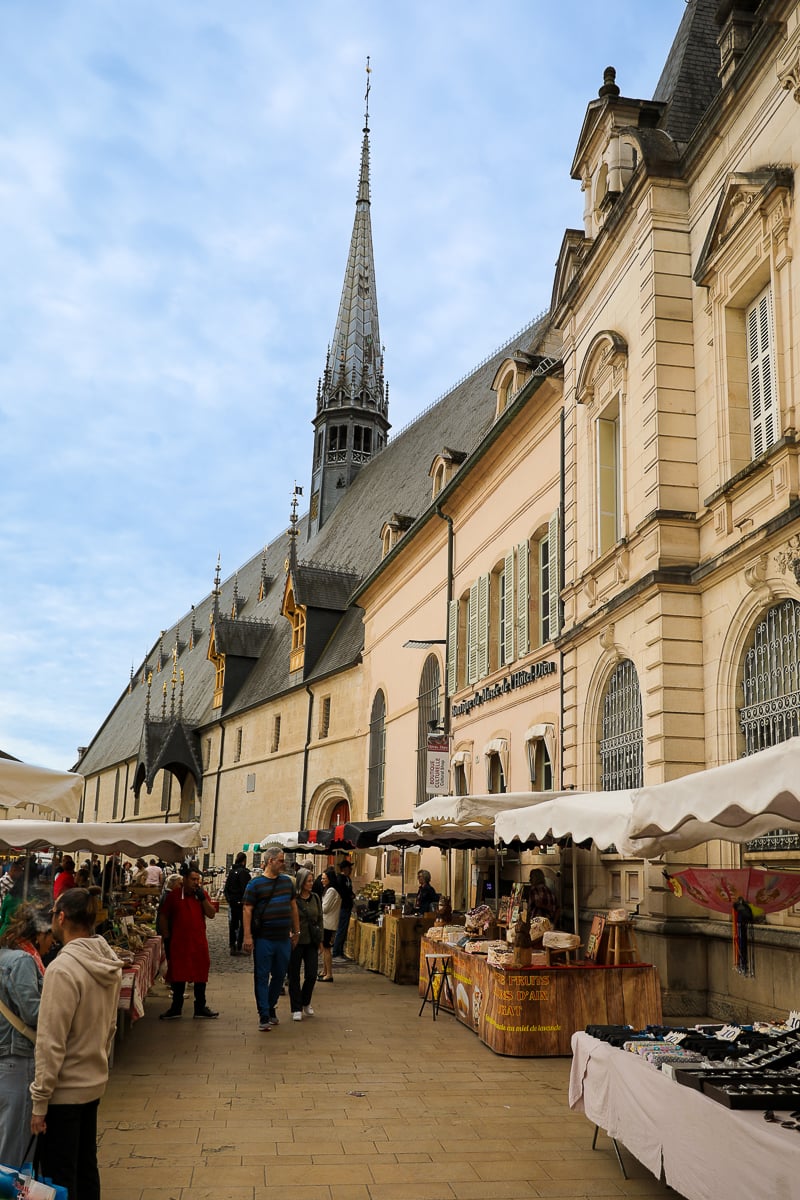 Saturday market stalls lining a historic street in central Beaune, Burgundy, France