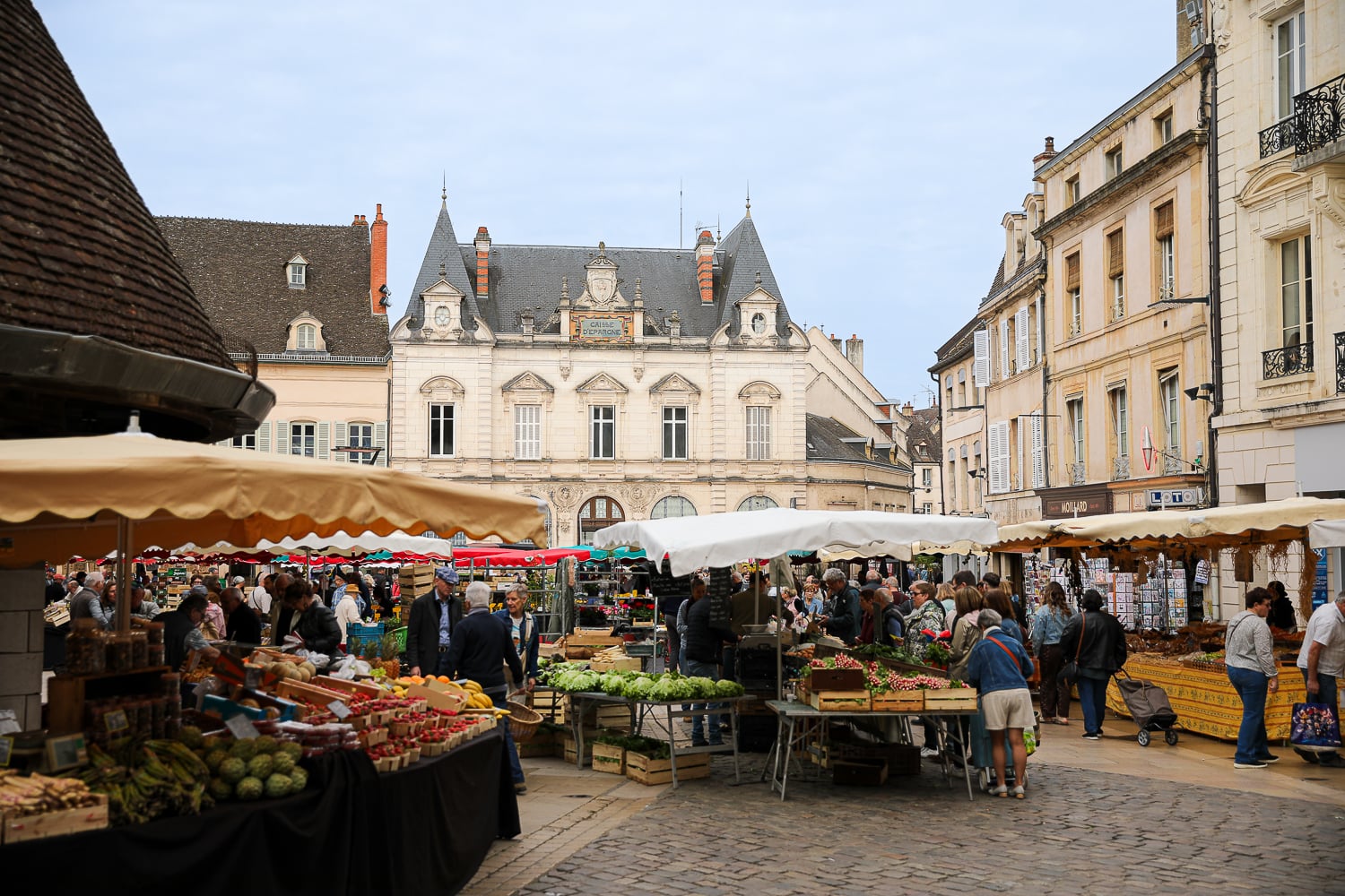 Beaune Market filled with fresh produce stalls and shoppers in the historic center of Beaune, France