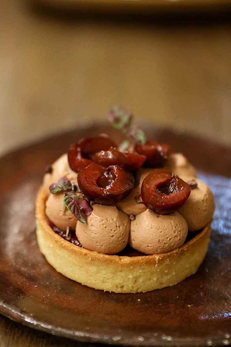 Chocolate and sour cherry tart topped with chocolate cream and cherries at Biz’tro Chic & Gourmand