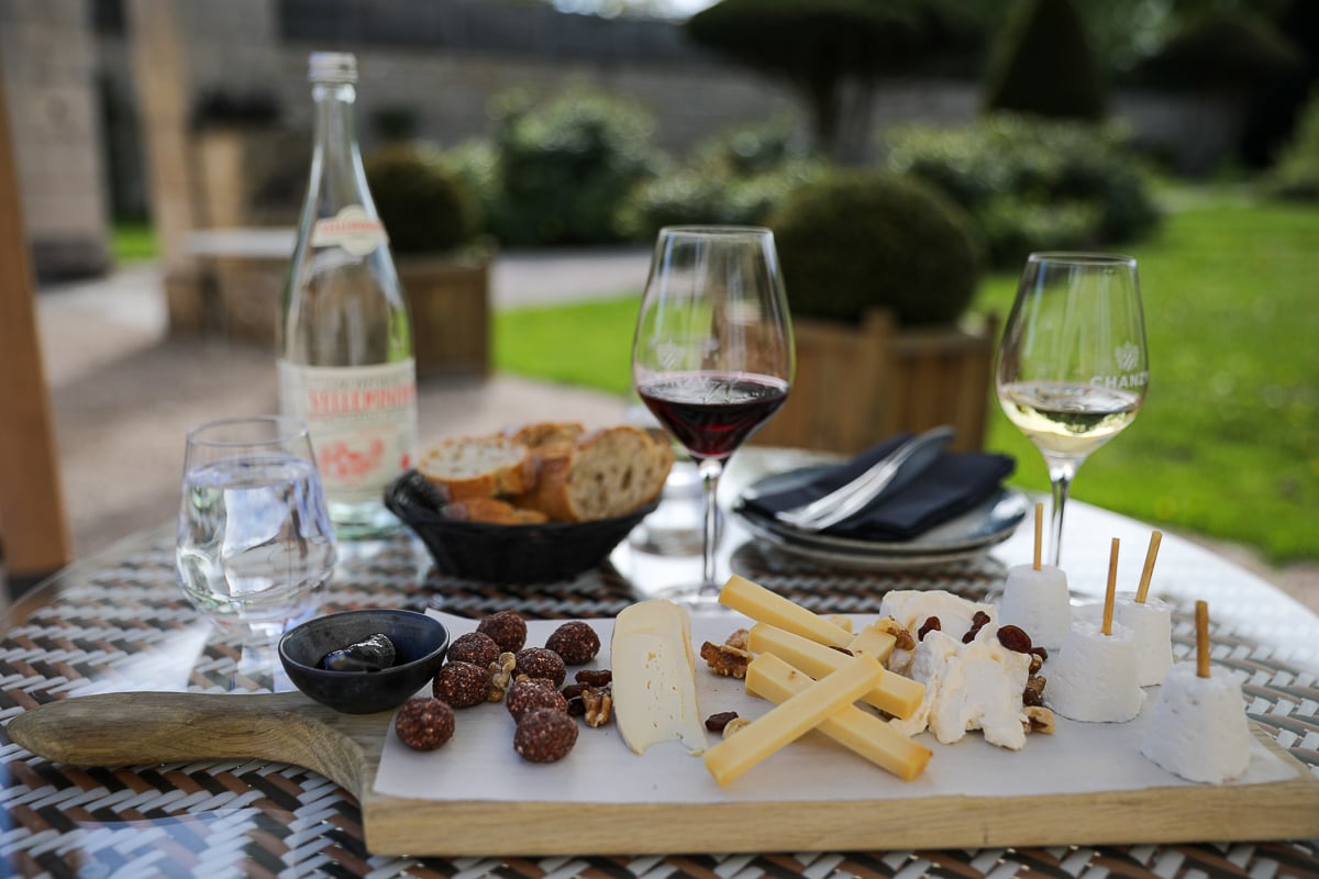 Burgundy cheese board with red and white wine during lunch in Puligny-Montrachet, France