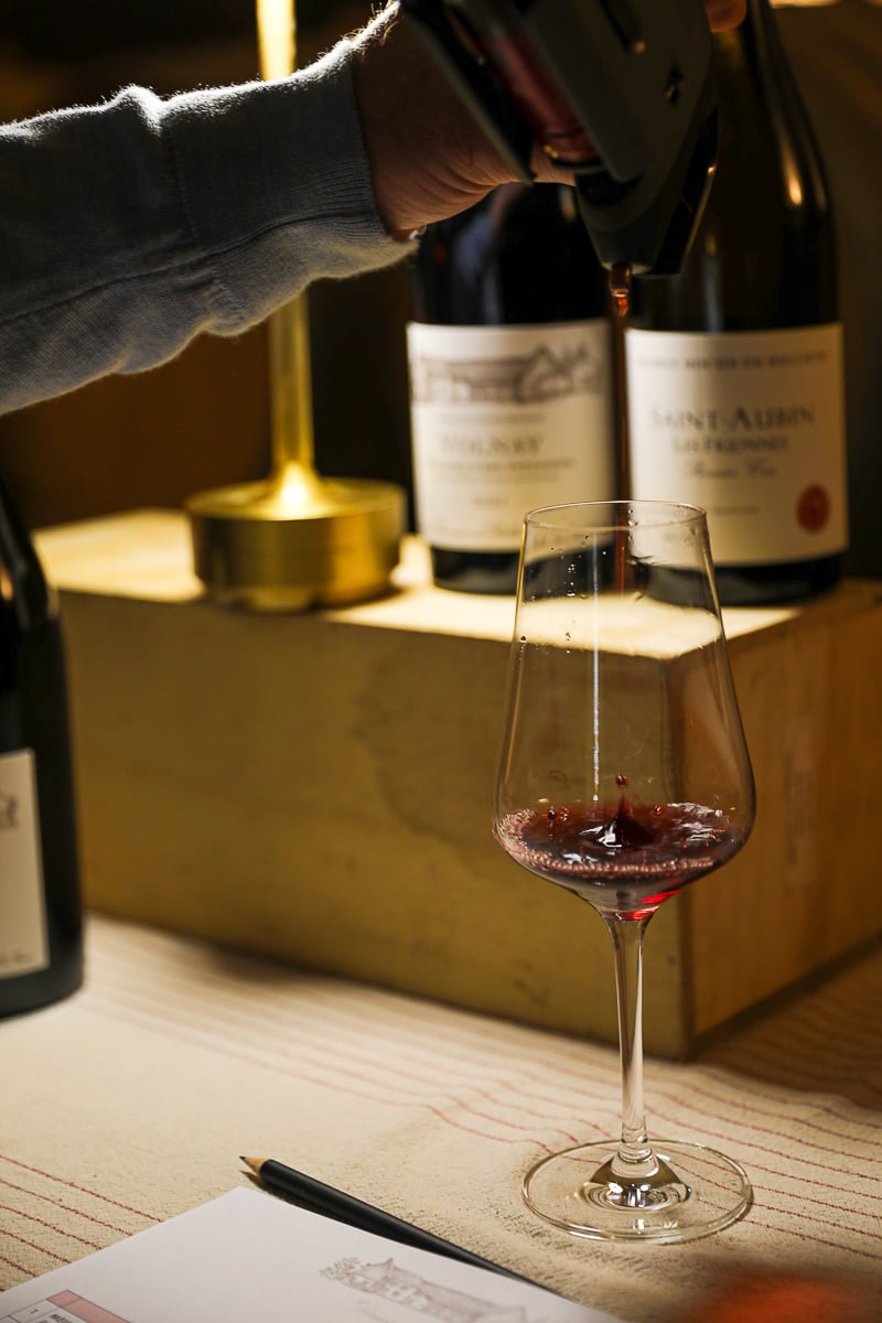 Red Burgundy wine being poured during a cellar tasting in the Côte de Beaune, France