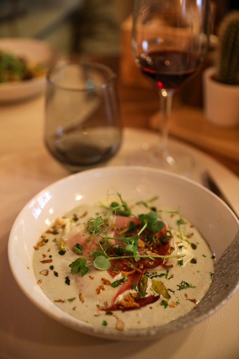 Eggs with asparagus, grilled bacon, greens, and creamy goat cheese sauce at La Table de Guigone
