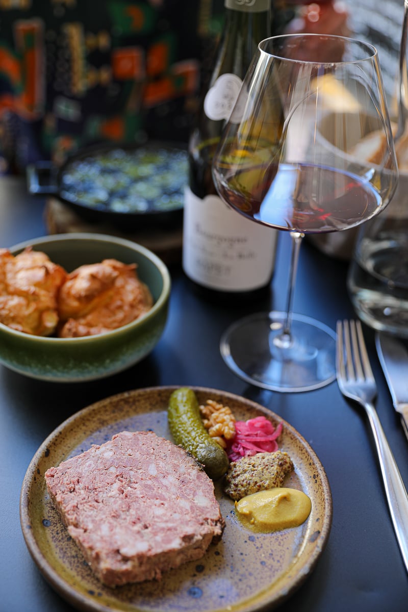 Rustic pork terrine with cornichons and mustard served with Burgundy red wine at Rebond restaurant