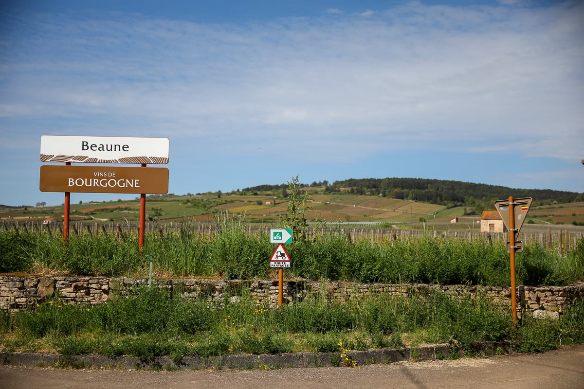 Beaune wine region sign beside vineyards and cycling trails in Burgundy, France