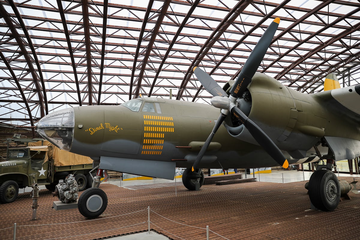 A restored B-26 Marauder bomber plane named ‘Dinah Might’ on display at the Utah Beach Museum in Normandy, featuring extensive bomb-tally markings on its fuselage.