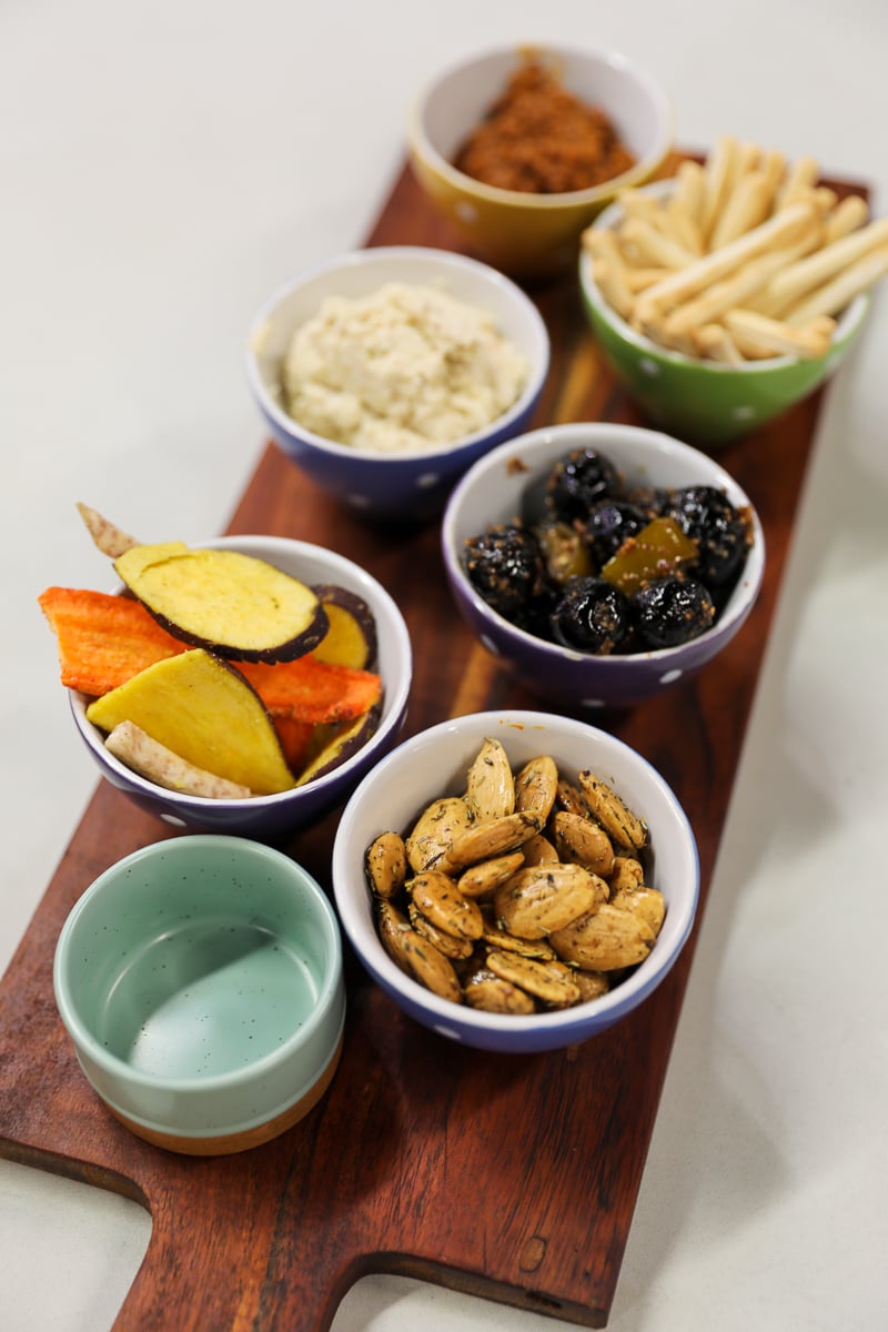 Bowls of olives, seasoned almonds, vegetable chips, breadsticks, and dips during an Avignon food tour