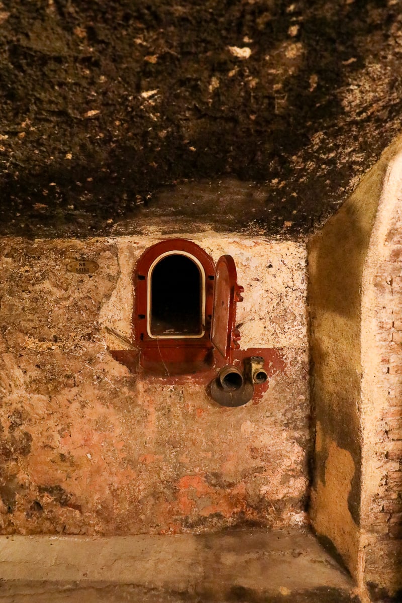 Historic stone wine tank built into the cellar wall at Château La Nerthe in Châteauneuf-du-Pape