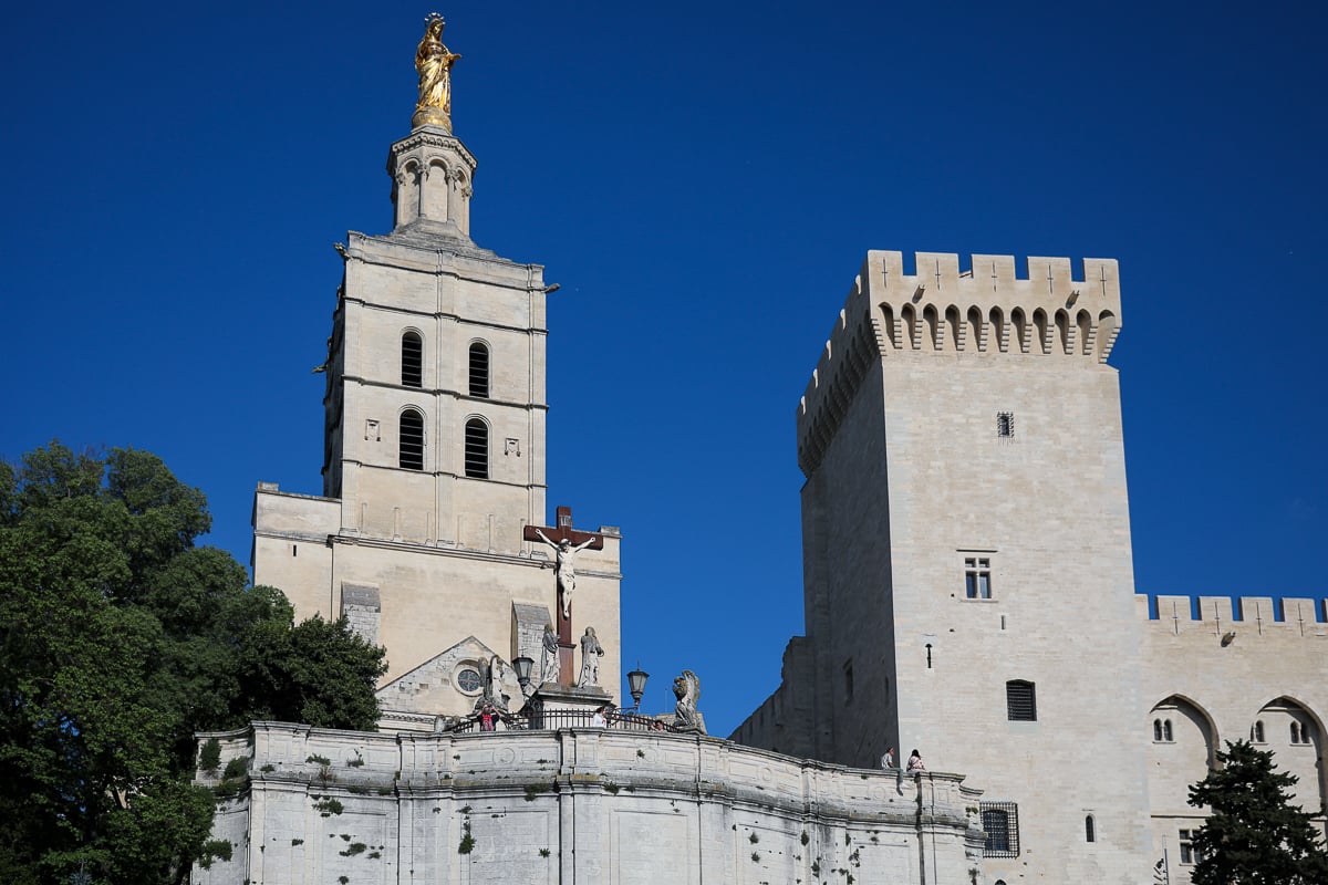 Notre-Dame des Doms Cathedral and Palais des Papes beneath a blue sky in Avignon